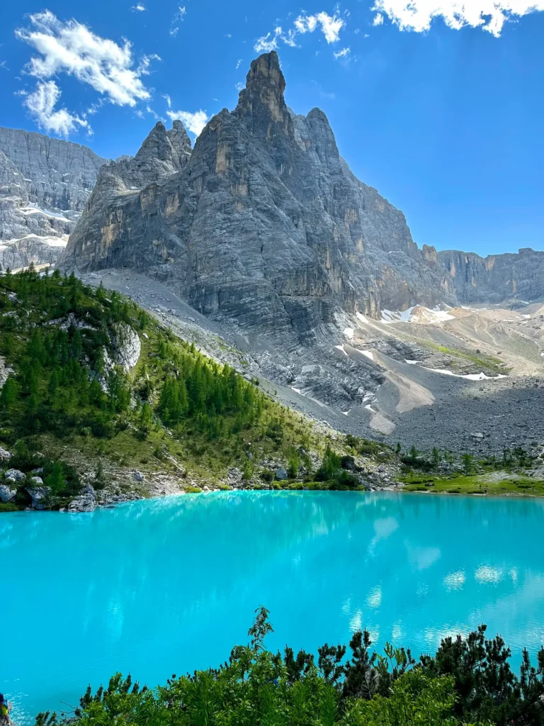 Blue lake Sorapis framed by mountain cliffs and branches